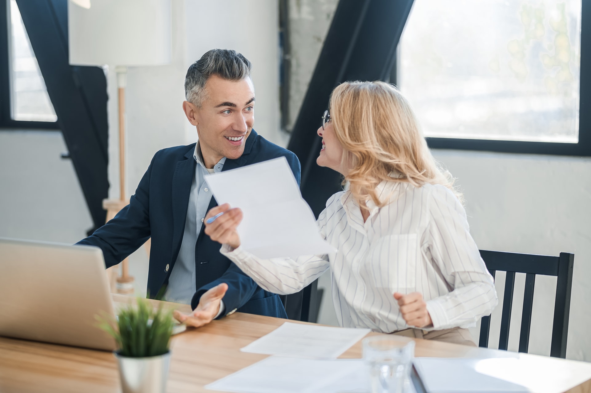 Spolumajitelé nemovitosti v pracovně prochází dokumenty k pronájmu bytu